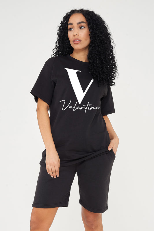 Woman wearing the black oversized Valantina Signature Graphic T-Shirt styled with casual bottoms, highlighting the front print and comfortable silhouette.