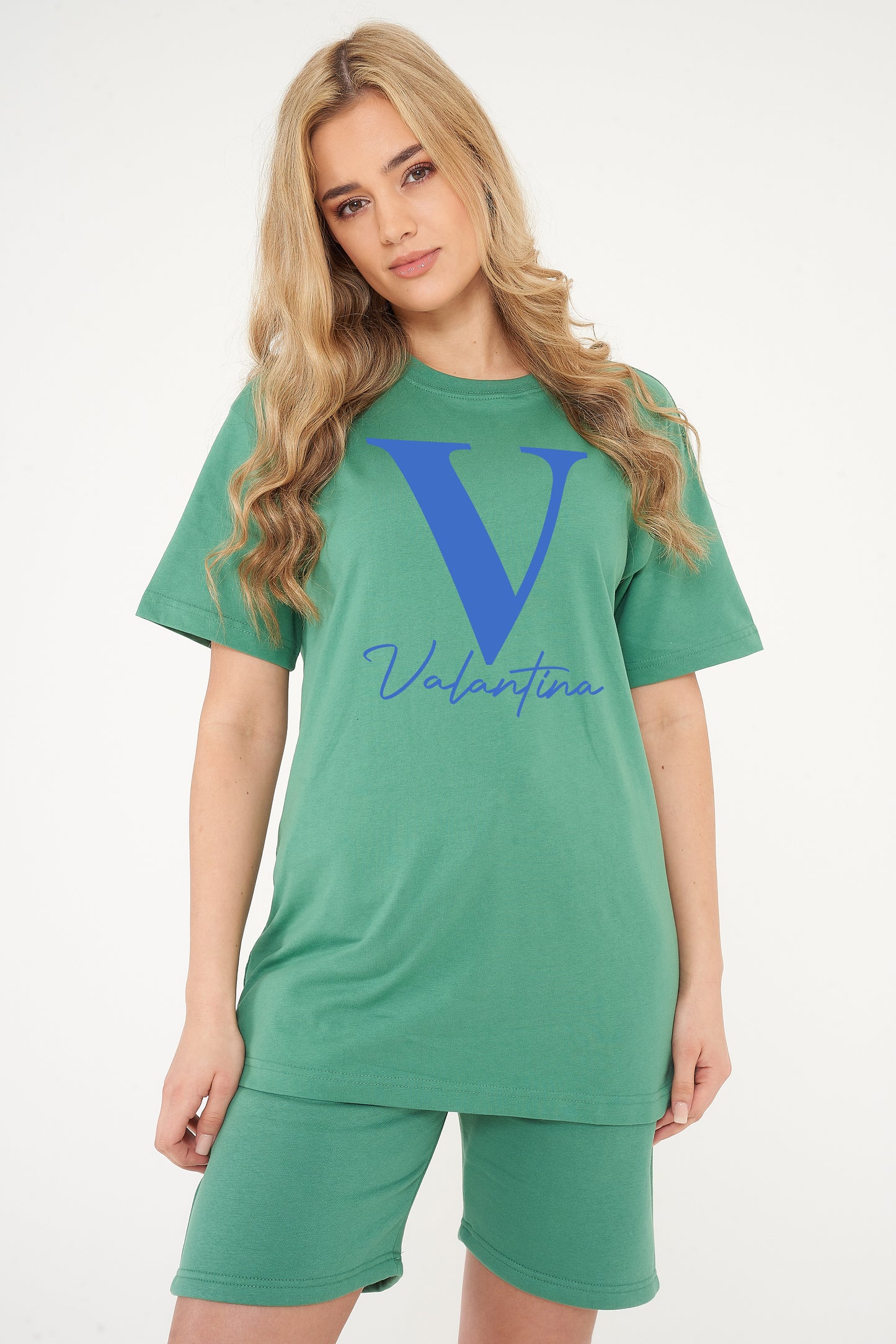 Woman wearing a green Valantina Signature Graphic T-Shirt styled with casual bottoms, highlighting the front signature print and comfortable silhouette.