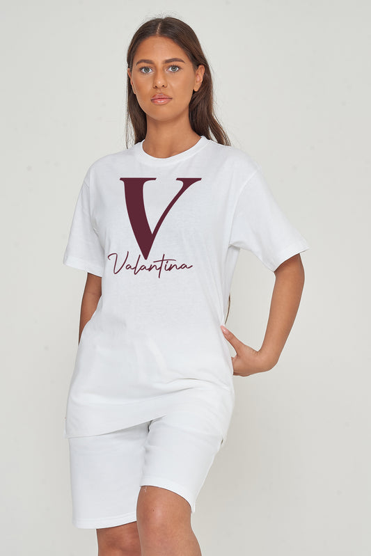 Woman wearing the white oversized Valantina Signature Graphic T-Shirt styled with casual bottoms, highlighting the front print and comfortable silhouette.