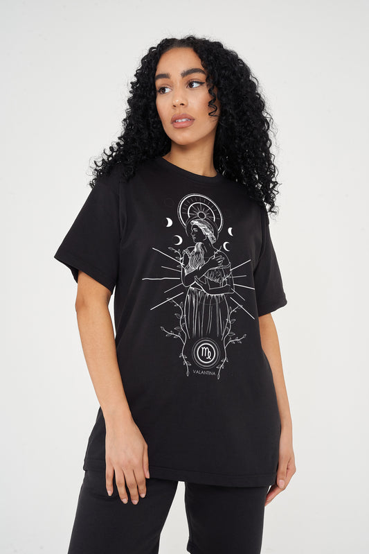 Woman wearing the black Virgo Zodiac Graphic T-Shirt styled with dark denim and casual boots, showcasing the front graphic and relaxed oversized fit.
