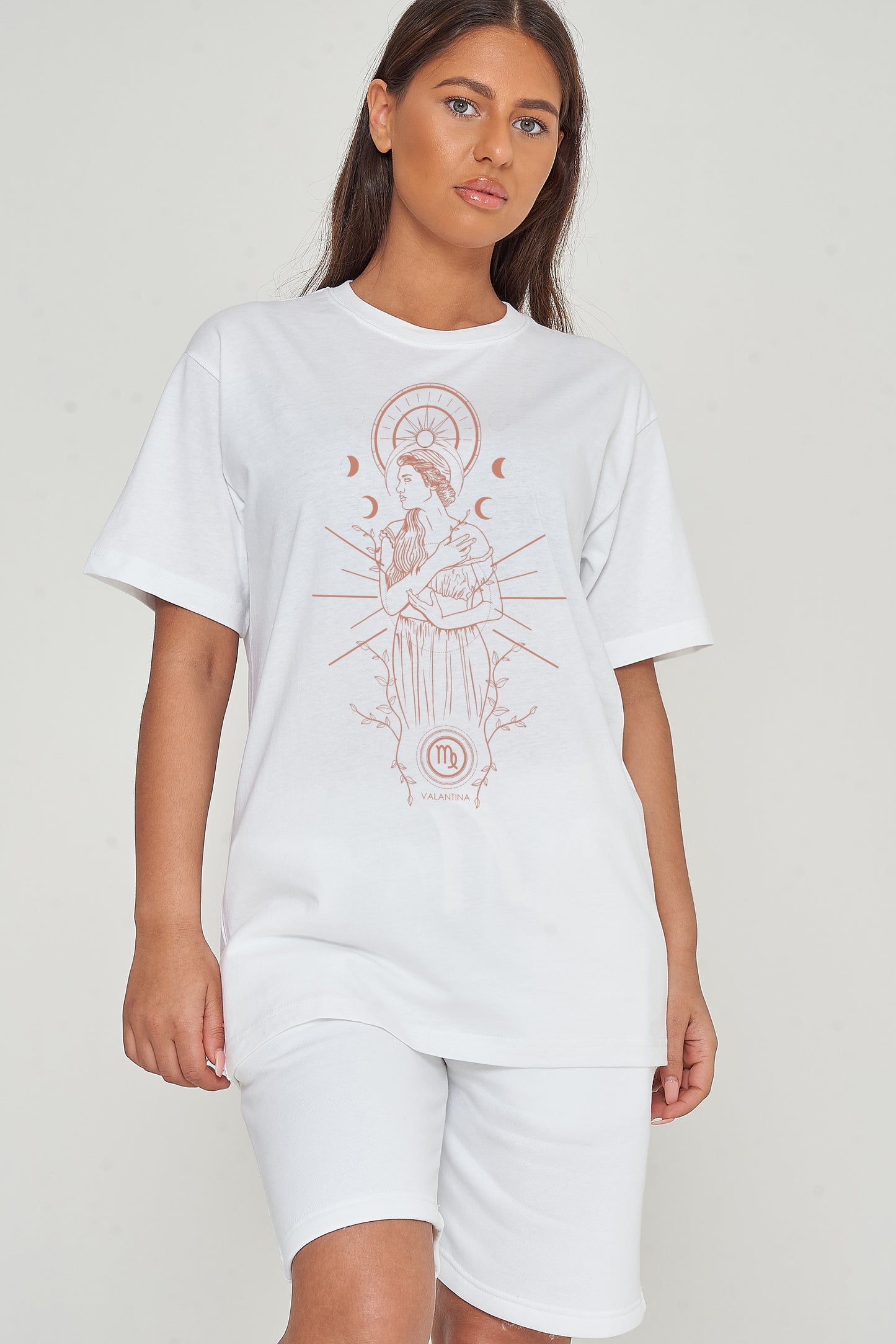 Woman wearing oversized white Virgo Zodiac Graphic T-Shirt styled with matching bottoms, showcasing the front graphic and relaxed fit.