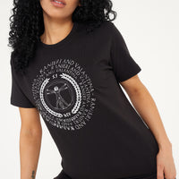 Woman wearing the black Vitruvian T-Shirt styled with casual denim bottoms, highlighting the front artistic print and comfortable oversized fit.