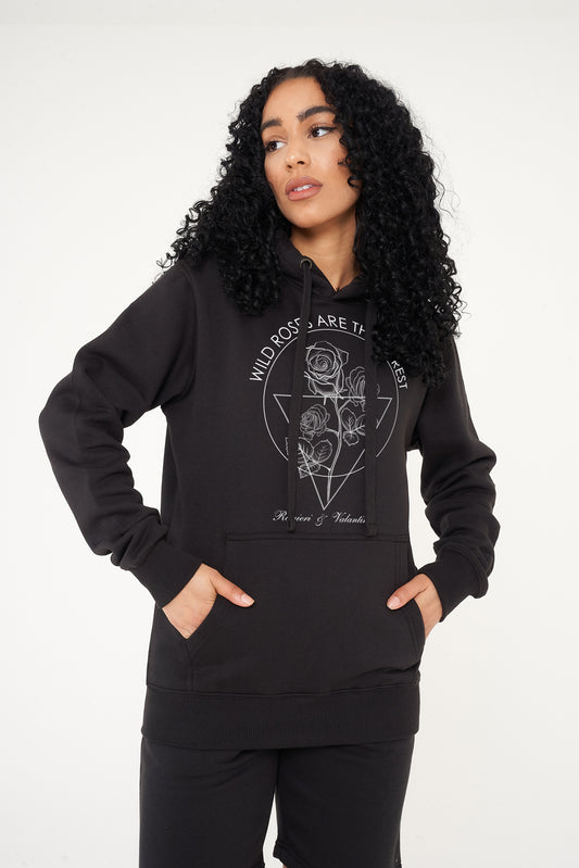 Woman wearing Wild Roses black hoodie for casual street style look.
